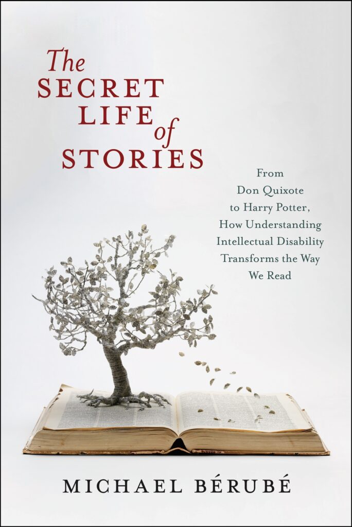 An open book lying flat on a white surface. A small tree with many branches sits atop the pages, showering its gray leaves onto the book.
