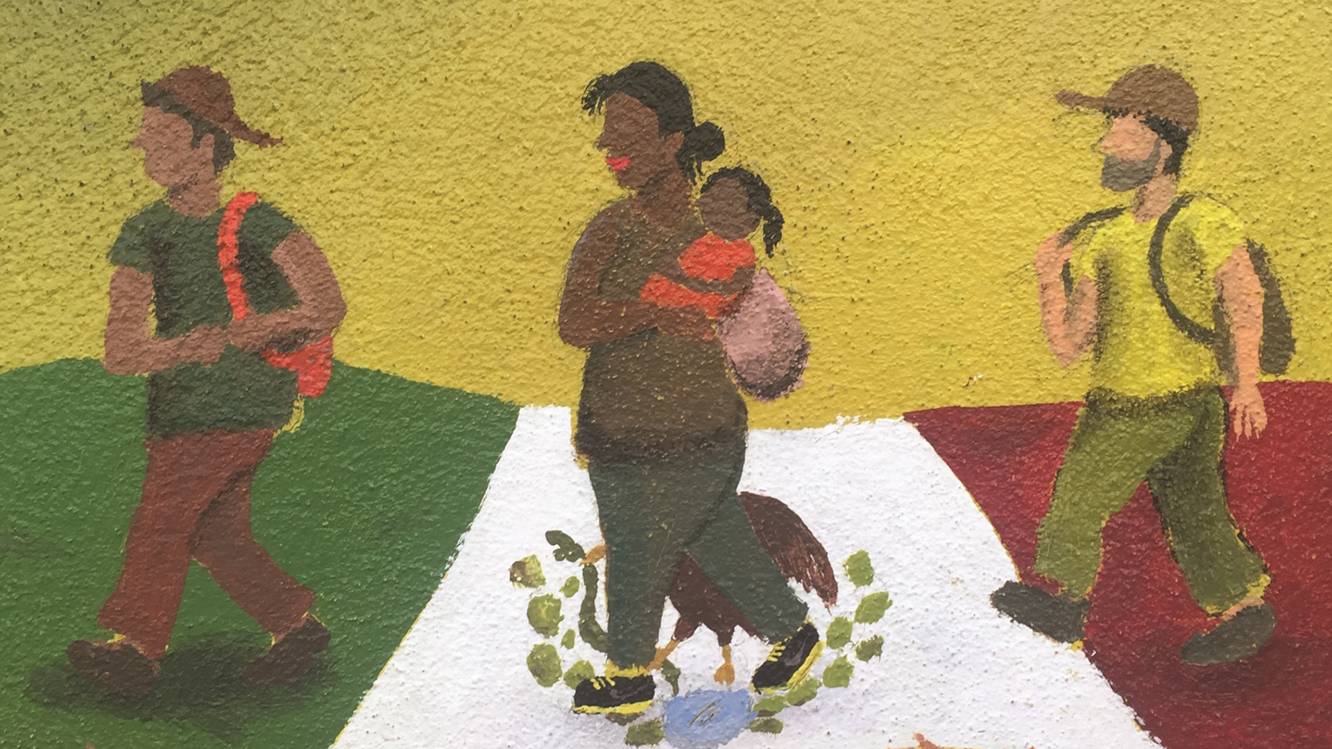 Mural of three migrants walking across the Mexican flag.