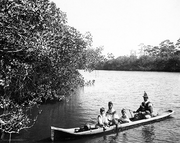 This image is titled, "Seminole Indians in a Canoe on the Miami River—Miami, Florida (1912)." From the eighteenth to the twentieth century, Seminole Indians traveled to the North Bank in dugout canoes in order to trade with its residents, gather supplies, and harvest coontie. Courtesy of the State Archives of Florida.