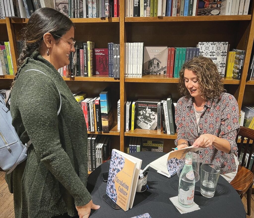 Jennifer Cearns, author of Circulating Culture: Transnational Cuban Networks of Exchange, speaking to an audience member while signing a copy of her book at an event at Books & Books in Coral Gables.
