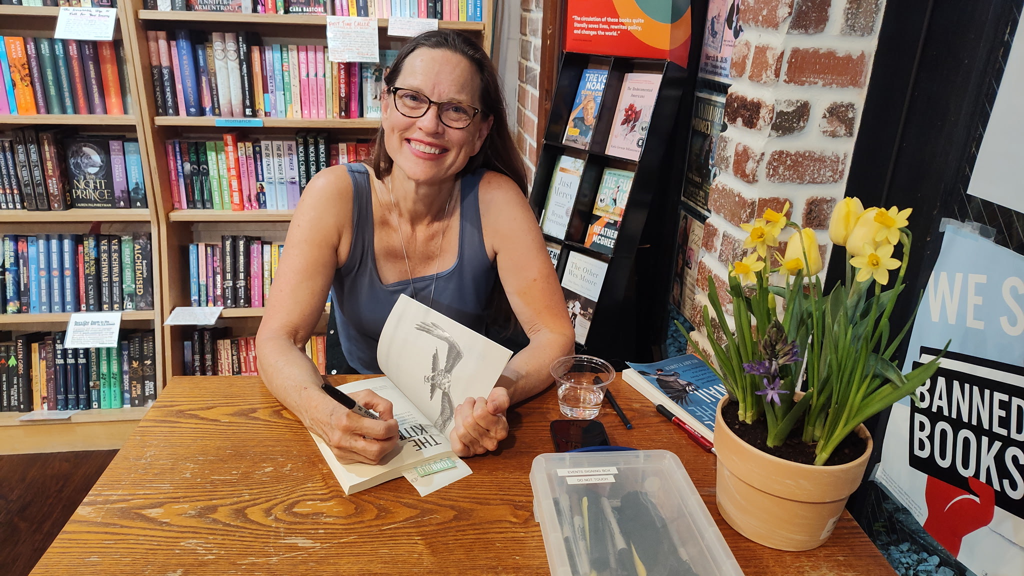 Hilary Flower pauses while signing a book in a bookstore.