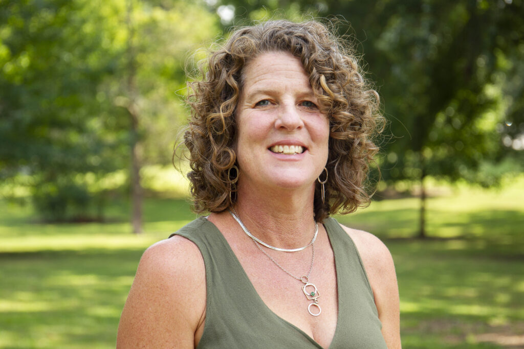 Author photo of Katya Wesolowski. She is wearing a green dress and smiling.